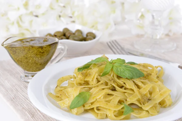 Delicious pasta with pesto on plate on table close-up — Stock Photo, Image