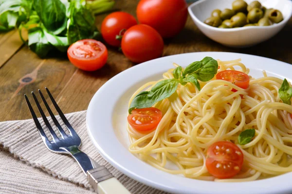 Delicious spaghetti with tomatoes on plate on table close-up — Stock Photo, Image