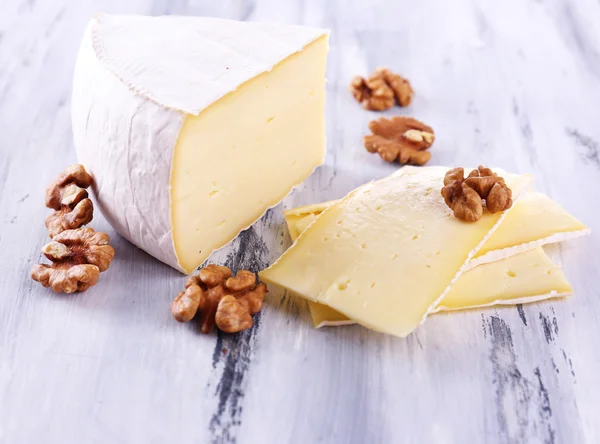 Sabroso queso Camembert con nueces, sobre mesa de madera — Foto de Stock