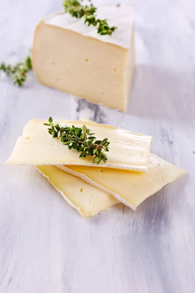 Tasty Camembert cheese with thyme, on wooden table — Stock Photo, Image