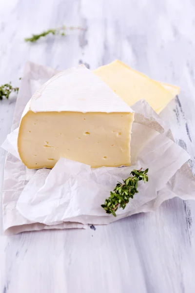 Sabroso queso Camembert con tomillo, sobre mesa de madera —  Fotos de Stock