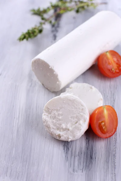 Queijo saboroso com tomilho e tomate, sobre mesa de madeira — Fotografia de Stock