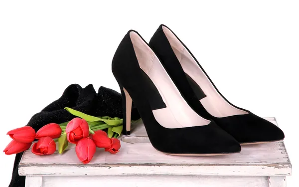Vackra svarta kvinnliga skor och blommor på vit bakgrund — Stockfoto