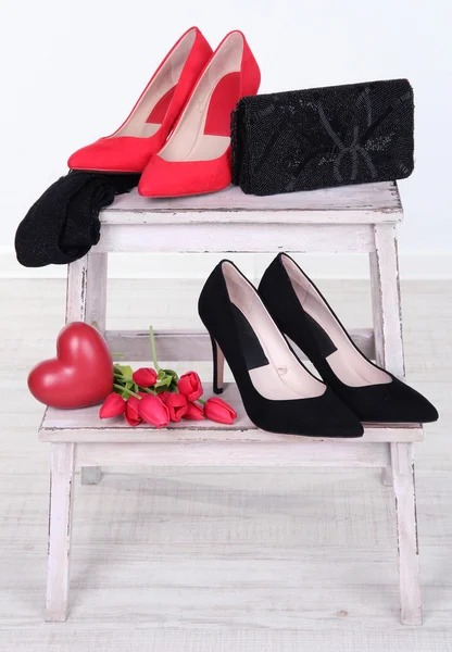 Belle scarpe femminili nere e rosse, borsa e fiori su sfondo bianco — Foto Stock