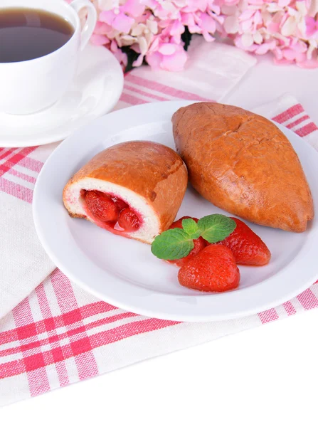Fresh baked pasties with strawberries on plate on table close-up — Stock Photo, Image
