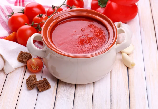 Sopa de tomate saborosa e legumes na mesa de madeira — Fotografia de Stock