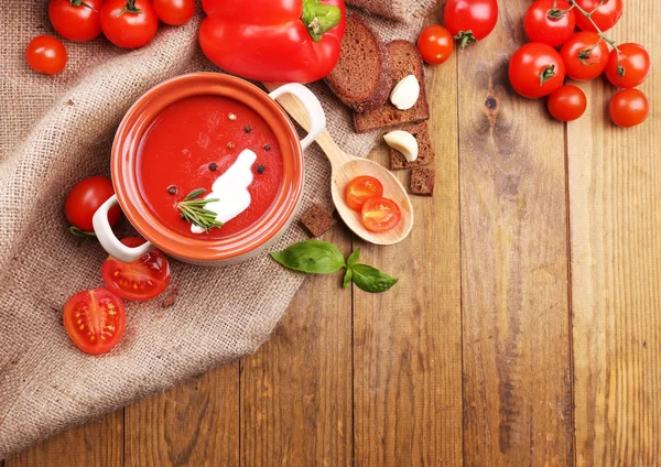 Sopa de tomate saborosa e legumes na mesa de madeira — Fotografia de Stock