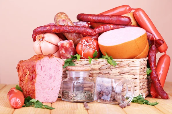 Lot of different sausages on wooden table on beige background — Stock Photo, Image