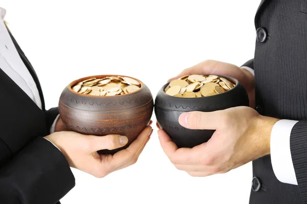 Twee keramische potten met gouden munten in mannelijke en vrouwelijke handen, geïsoleerd op witte achtergrond — Stockfoto