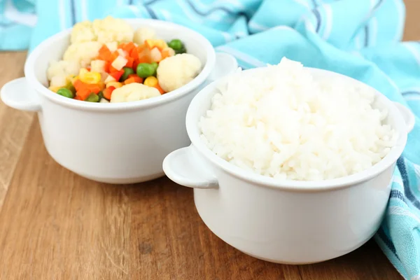 Gekookte rijst met groenten op houten tafel close-up — Stockfoto