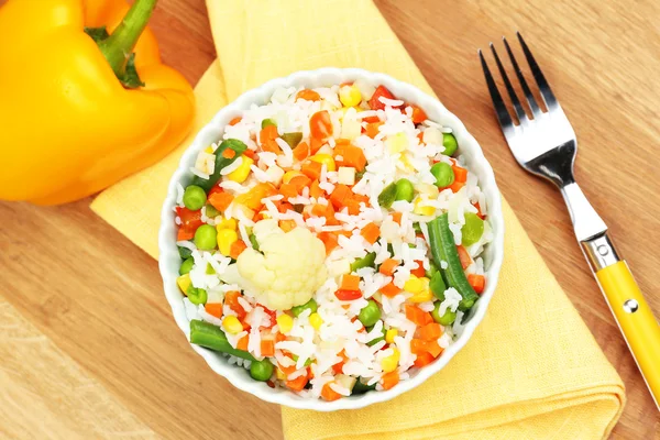 Cooked rice with vegetables on wooden table — Stock Photo, Image