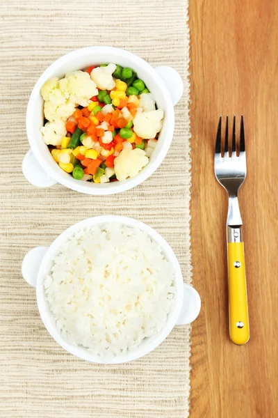 Gekookte rijst met groenten op houten tafel — Stockfoto