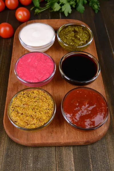 Verschiedene Saucen auf Schneidebrett auf dem Tisch in Großaufnahme — Stockfoto