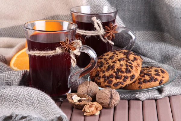 Mulled wine with oranges and cookies on table on fabric background — Stock Photo, Image