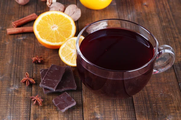 Vinho ruminado com laranja e especiarias em fundo de madeira — Fotografia de Stock