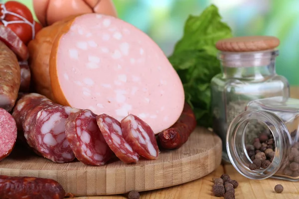 Verschillende worstjes op houten tafel op natuurlijke achtergrond — Stockfoto