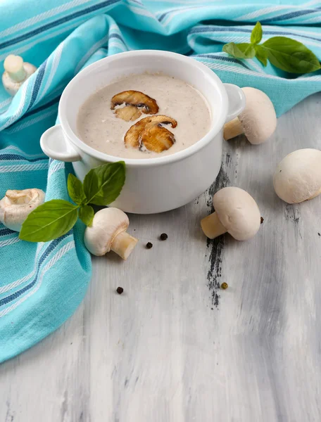 Mushroom soup in white pot, on napkin,  on wooden background — Stock Photo, Image