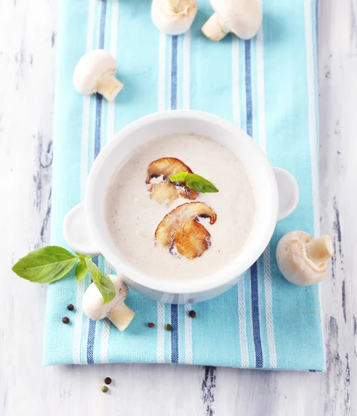 Mushroom soup in white pot, on napkin,  on wooden background — Stock Photo, Image