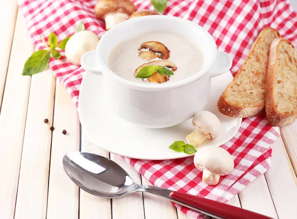 在白色的锅里，餐巾，木制的背景上的蘑菇汤 — 图库照片