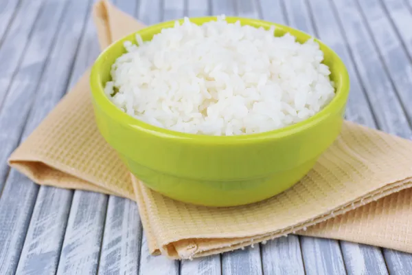 Cooked rice in bowl on wooden background — Stock Photo, Image