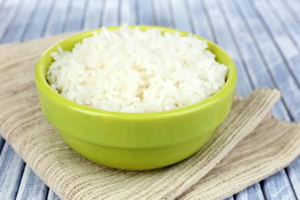 Arroz cozido em tigela no fundo de madeira — Fotografia de Stock