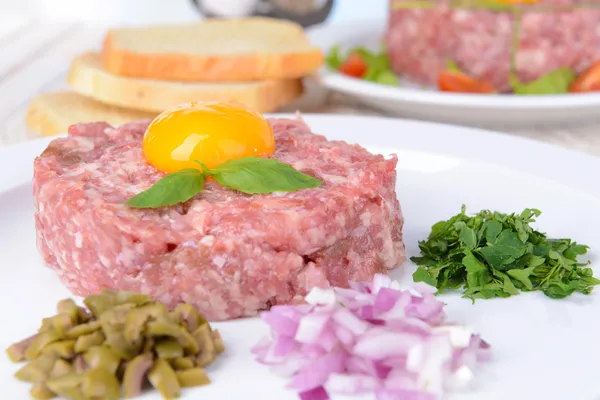 Delicioso bife tartare com gema de ovo na placa na mesa close-up — Fotografia de Stock