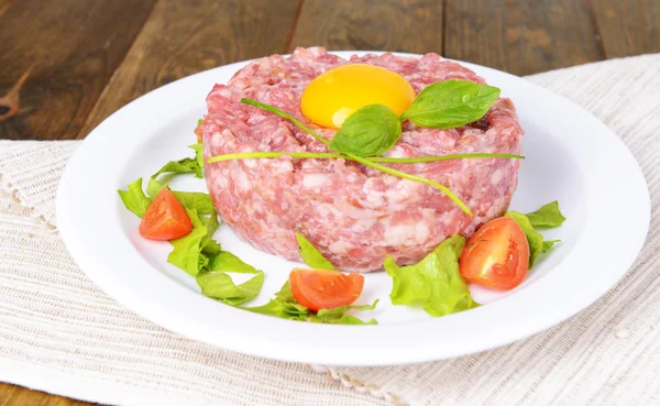 Delicioso bife tartare com gema de ovo na placa na mesa close-up — Fotografia de Stock