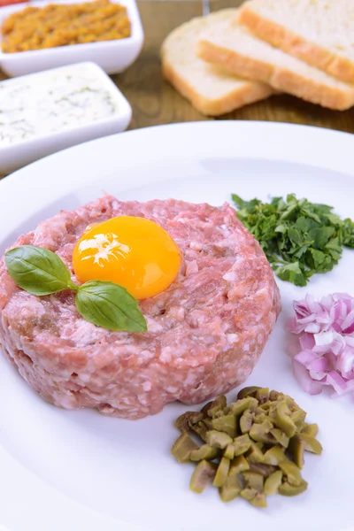 Delicious steak tartare with yolk on plate on table close-up — Stock Photo, Image