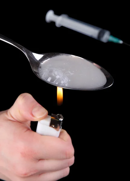 Heroin in spoon on black background — Stock Photo, Image