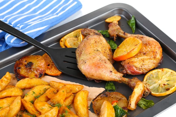 Homemade roasted chicken drumsticks with fried potatoes and vegetables on pan, isolated on white — Stock Photo, Image