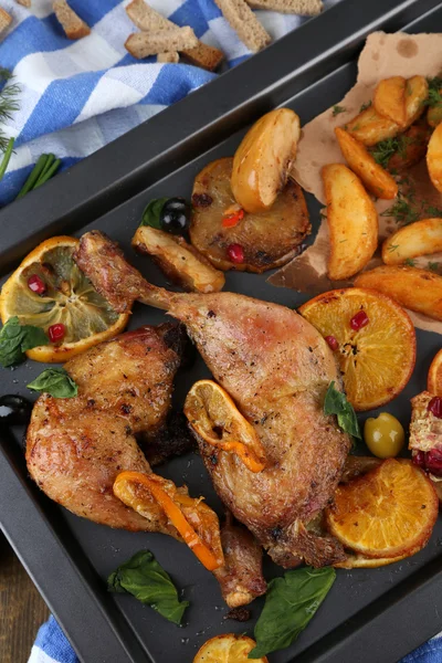 Palitos de pollo asados caseros con papas fritas y verduras en la sartén, sobre fondo de madera — Foto de Stock