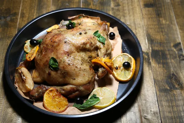 Whole roasted chicken with vegetables on pan, on wooden background — Stock Photo, Image