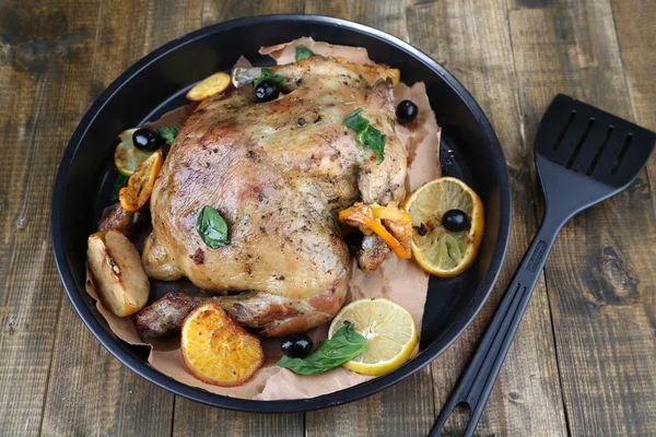 Whole roasted chicken with vegetables on pan, on wooden background — Stock Photo, Image