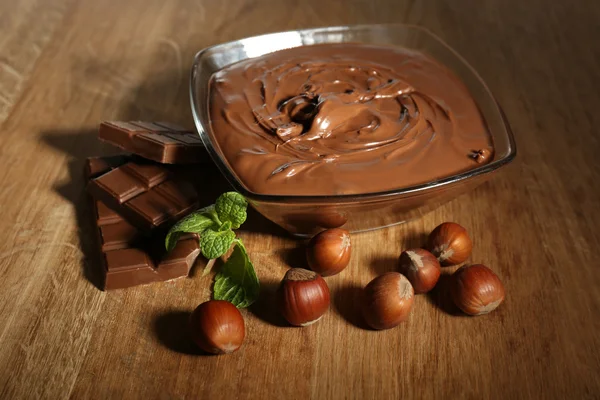 Avellana de chocolate dulce untada con nueces enteras y menta sobre fondo de madera —  Fotos de Stock