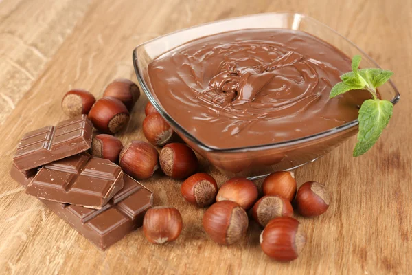 Солодкий шоколадний лісовий горіх, поширений з цілими горіхами та м'ятою на дерев'яному фоні — стокове фото
