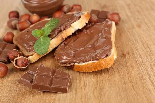 Pan con avellana de chocolate dulce sobre fondo de madera — Foto de Stock