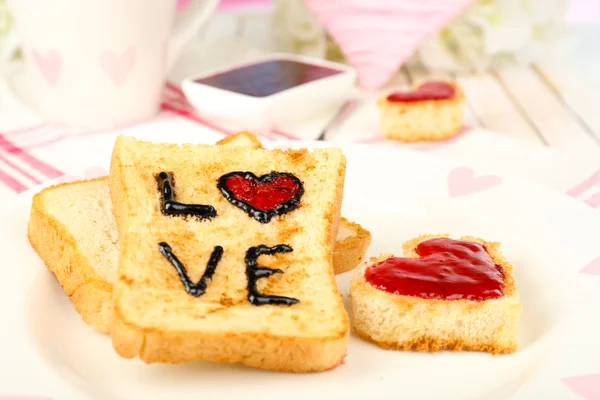 Delicious toast with jam and cup of tea on table close-up — Stock Photo, Image