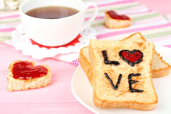 Delicious toast with jam and cup of tea on table close-up — Stock Photo, Image