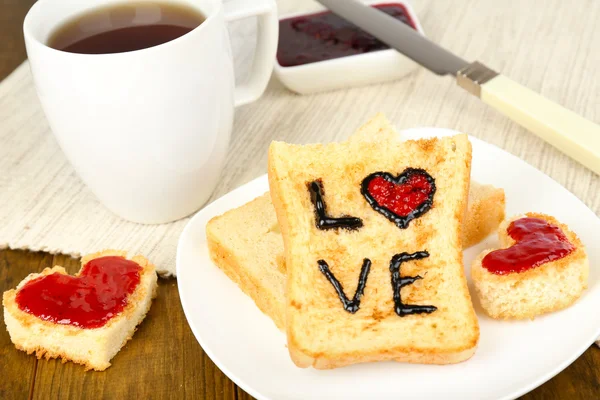 Läckra toast med sylt och kopp te på bordet närbild — Stockfoto