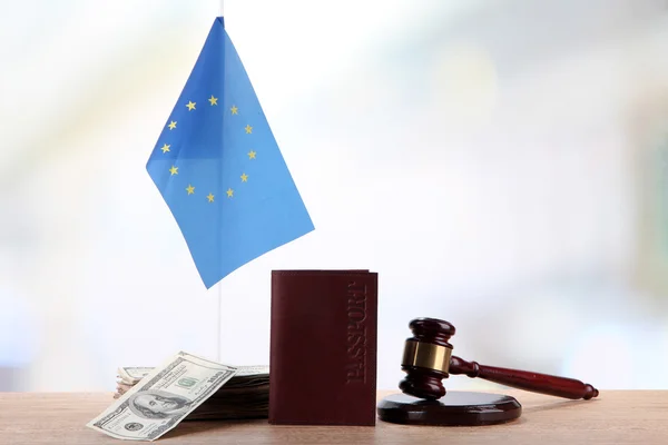 Martillo, dinero, pasaporte y bandera de Europa, sobre mesa de madera, sobre fondo claro — Foto de Stock