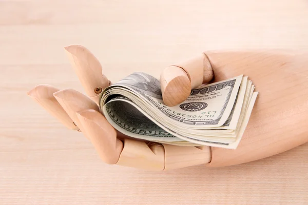 Money in wooden hand, on wooden background — Stock Photo, Image