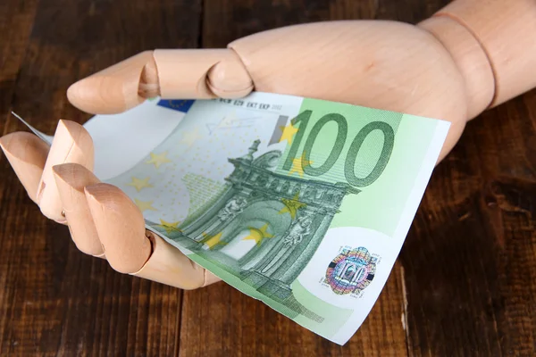 Geld in Holzhand, auf farbigem Holzgrund — Stockfoto