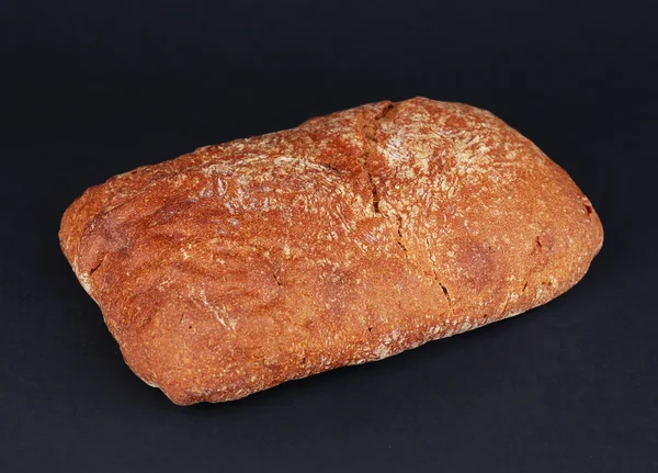 Буханка хлеба на черном фоне — стоковое фото