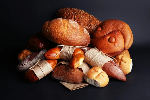Différents types de pain sur fond noir, gros plan — Photo