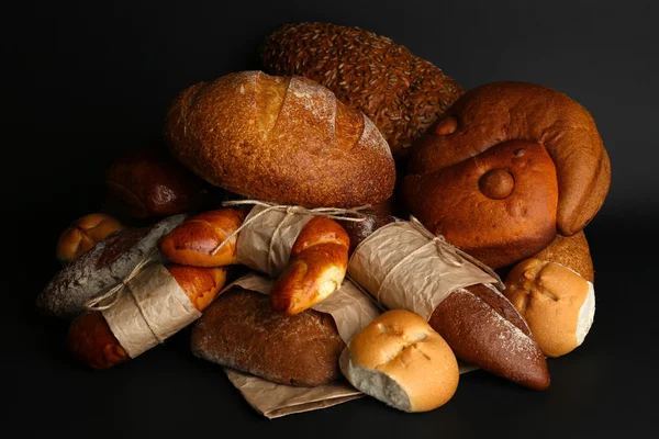 Различные виды хлеба на черном фоне, крупным планом — стоковое фото