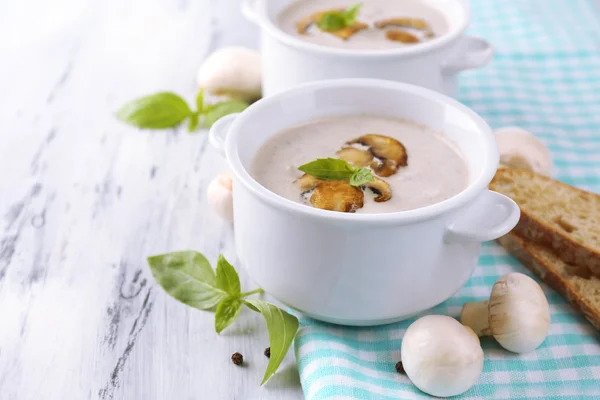 Mushroom soup in white pots, on napkin, on wooden background — Stock Image Mushroom soup in white pots, on napkin, on wooden background Royalty Free Stock Images
