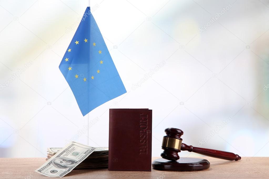 Gavel, money, passport and flag of Europe, on wooden table, on light background
