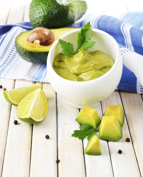 Fresh guacamole in bowl on wooden table — Stock Photo, Image