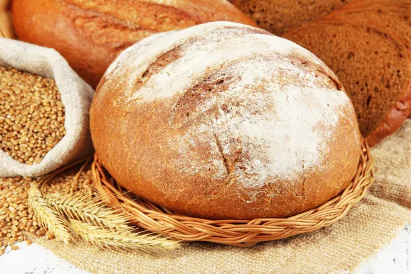 Pane di segale con grani su sacco sul tavolo da vicino — Foto Stock