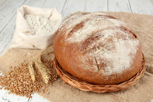 Pain de seigle avec farine et grains sur le sac sur la table fermer — Photo